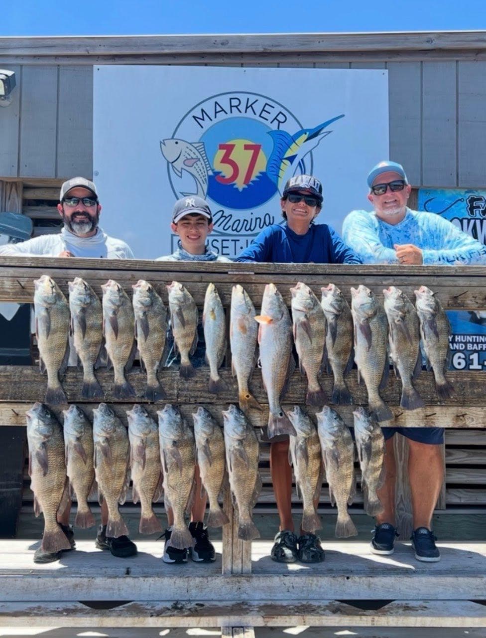 Family and friends showing off a full day's catch at the marina